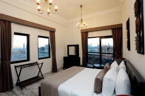 a bedroom with a bed and a balcony with windows at Marbella Holiday Homes in Dubai