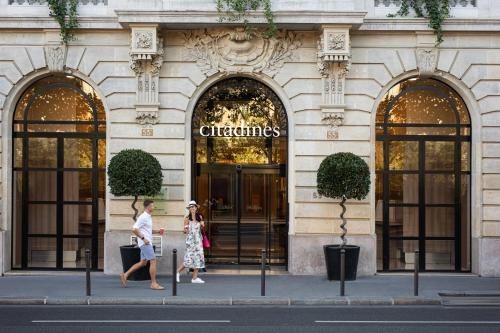 two people walking down the street in front of a building at Citadines Saint-Germain-des-Prés Paris in Paris