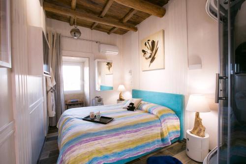 1 dormitorio con 1 cama con una manta colorida en ROUTE 66 SPA, en Vignanello