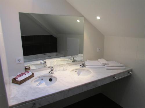a bathroom with two sinks and a large mirror at Posada Real El Brasilero in Saucelle