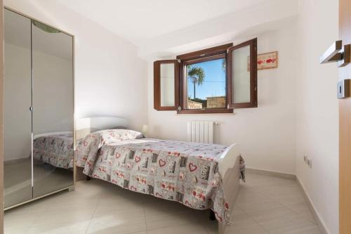 1 dormitorio con cama, espejo y ventana en Dependance di Villa Melissa, en Parabita