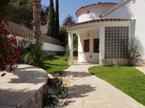 a white house with a pathway leading to the front yard at Hauzify I Villa Parc in Hospitalet de l'Infant