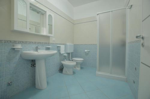 a bathroom with a sink and a toilet and a shower at Holiday Apartments Azzurro Salento in Torre Vado