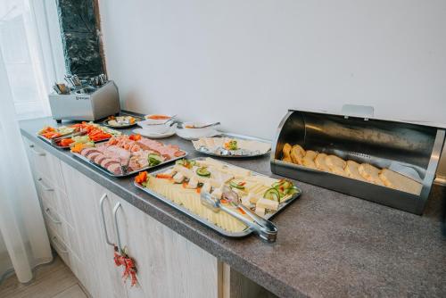 a kitchen counter with many different types of food at Vila Ursul Negru in Sovata