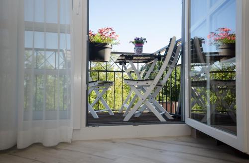 a balcony with a chair and a table with potted plants at Hotel Lange in Leer