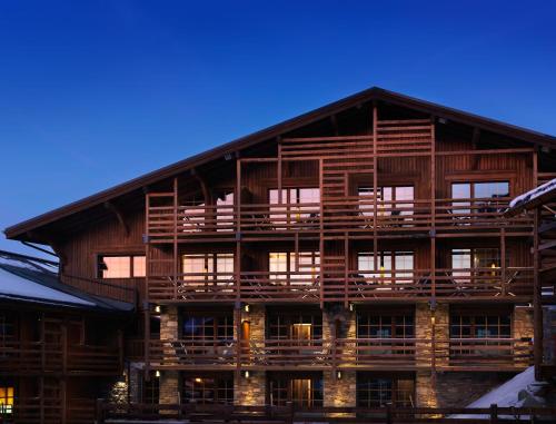 a large wooden building with many windows on it at M de Megève in Megève