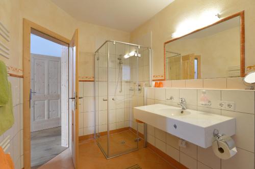 a bathroom with a sink and a shower and a mirror at Landhaus Jägerhof in Going