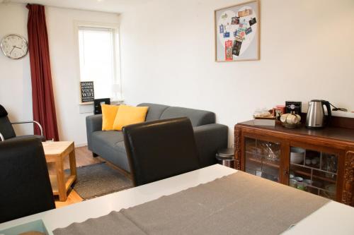 een woonkamer met een bank en een tafel bij Appartement Lefferts in Zandvoort