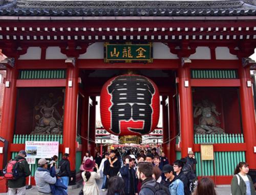 a crowd of people standing outside of a building with a sign at Tokyo inn Sakura An in Tokyo