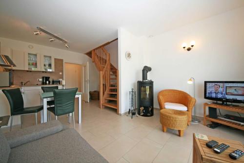 a living room with a couch and a tv and a kitchen at Haus Möwe Whg 02 mit Balkon & Terrasse in Thiessow