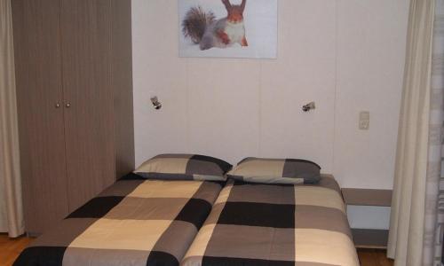 a bedroom with a bed with a checkered blanket at Camping de Watertoren in Landgraaf
