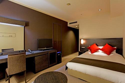 a hotel room with two beds and a television at Century Royal Hotel Sapporo in Sapporo