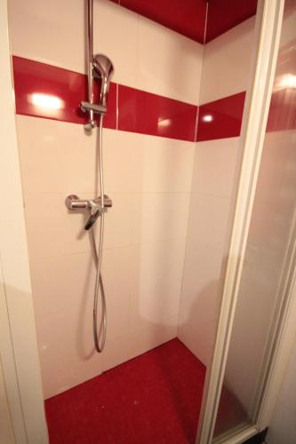 a bathroom with a shower with red and white tiles at YMMO 75012 in Paris