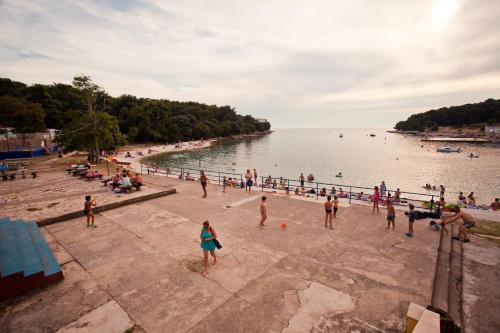 a group of people on a beach near the water at HI Hostel Pula in Pula