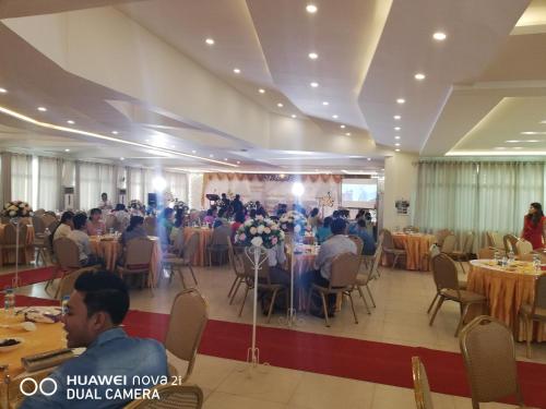 un gruppo di persone seduti ai tavoli in una sala banchetti di Supreme Hotel Yangon a Yangon