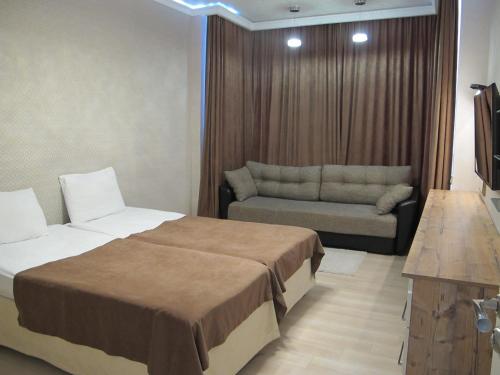 アドレルにあるApartment Na Staroobryadcheskoyのベッドとソファ付きのホテルルーム