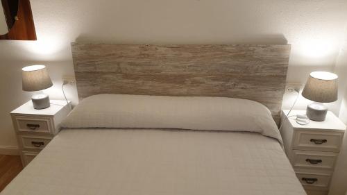 a bedroom with a white bed with two night stands at Apartamento La Ruta Del Vino in Haro