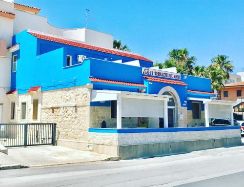 un edificio blu sul lato di una strada di Terrazze Sul Mare a Pozzallo