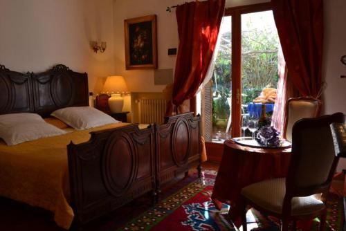 um quarto com uma grande cama de madeira e uma janela em Agriturismo Terre di Mare Bordighera em Vallecrosia