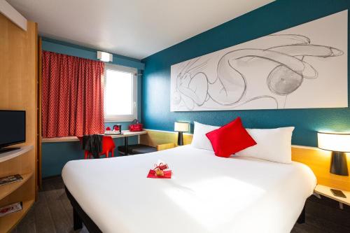 ペサックにあるibis Bordeaux Pessac Route des Vinsの大きなベッド(赤い枕付)が備わる客室です。
