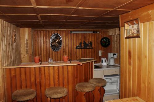 - une cuisine avec un comptoir et des tabourets dans une pièce dans l'établissement Ferienhaus Wittmann, à Kurort Oberwiesenthal