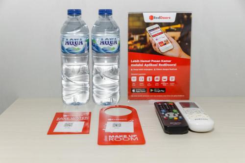 a bottle of water and a remote control and a box at RedDoorz Plus near Transmart Kairagi Dua manado in Manado