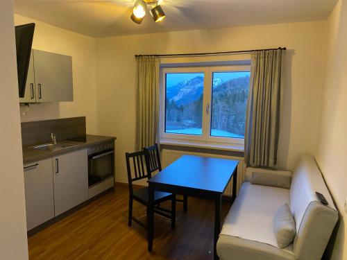 a living room with a table and a couch and a kitchen at Kaiserblick Apartments in Oberau