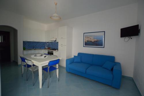 sala de estar con sofá azul y mesa en Holiday Apartments Azzurro Salento, en Torre Vado