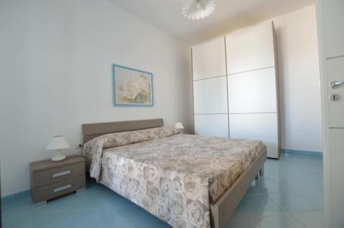 a bedroom with a bed and a dresser and a night stand at Holiday Apartments Azzurro Salento in Torre Vado