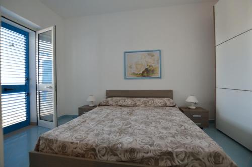 a bedroom with a bed and two night stands at Holiday Apartments Azzurro Salento in Torre Vado