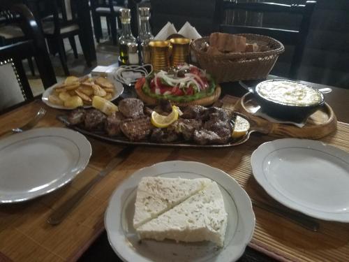a table topped with plates of food and a cake at Thethi Paradise Hotel & Restaurant in Theth