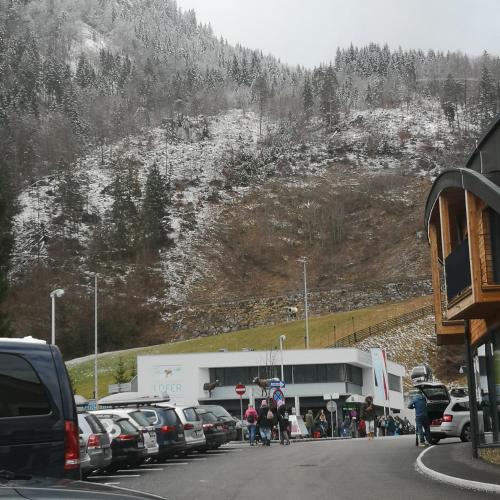 a parking lot with cars parked on the side of a mountain at MaHome Apartments in Lofer