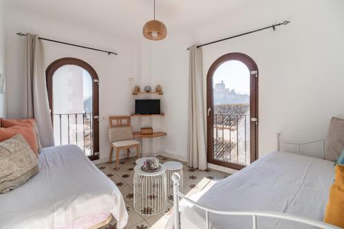 a bedroom with a bed and two large windows at Casa Quijada in Granada