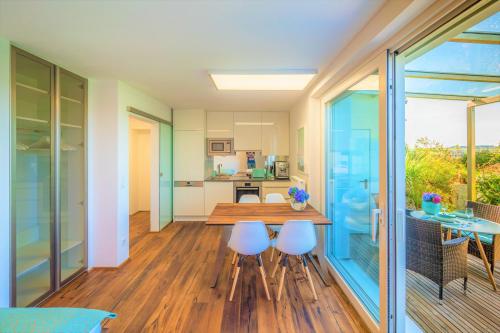 a kitchen and dining room with a table and chairs at Haus am Weinberg II in Seekirchen am Wallersee