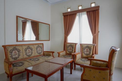 ein Wohnzimmer mit einem Sofa, 2 Stühlen und einem Tisch in der Unterkunft RedDoorz near Stadion 45 Karanganyar in Karanganyar