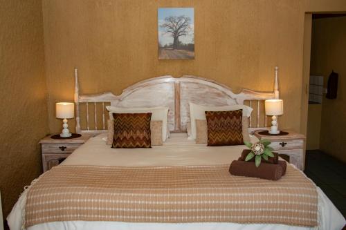a bedroom with a large bed with two lamps at Elephant's Nest in Graskop