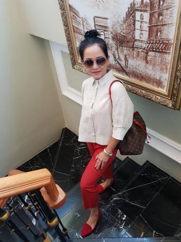 a woman in red pants and a white shirt and sunglasses at A Villa Hua Hin Hotel in Hua Hin