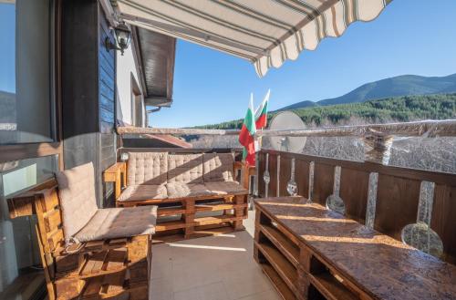 a balcony with benches and a view of the mountains at Апартаменти Ковачева-2 in Bansko
