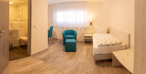 ein Krankenhauszimmer mit einem Bett und einem Stuhl in der Unterkunft Kloster Maria Hilf in Bühl