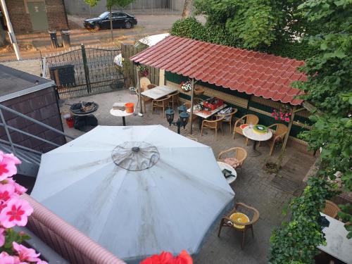 a white umbrella on a patio with a table and chairs at De Zevende Hemel in Kerkrade
