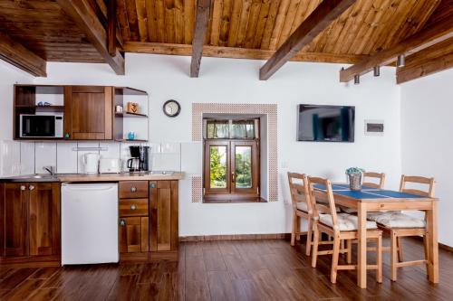 a kitchen with a wooden table and a table and chairs at Rózsa Porta in Zengővárkony