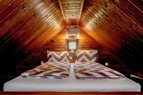 una camera con un letto in una cabina di legno di Rózsa Porta a Zengővárkony