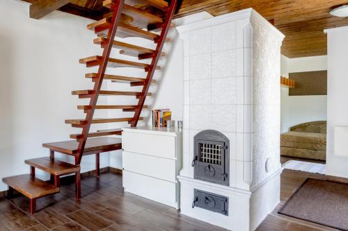 a living room with a staircase and a fireplace at Rózsa Porta in Zengővárkony