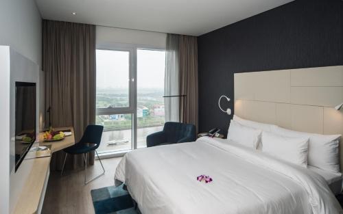 a hotel room with a large bed and a window at Liberty Central Saigon Riverside Hotel in Ho Chi Minh City