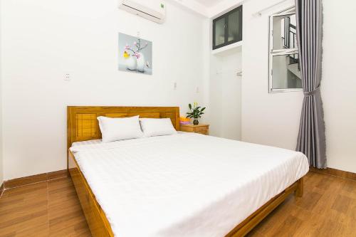 a bedroom with a bed with white sheets and a window at SPOT ON 806 Net Viet Homestay in Danang