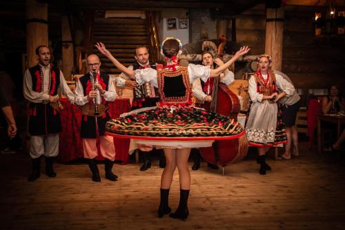 a group of people in traditional costumes with a woman in a large dress at Skansen Holiday in Cholerzyn