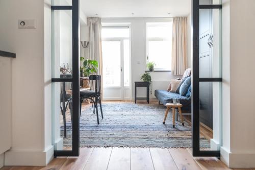 a living room with a mirror and a blue couch at Gorgeous And Stylish Place For Two In Hip West! in Amsterdam