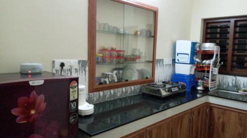 a kitchen with a counter top with a refrigerator at Wayanad Snow Vibes in Vythiri