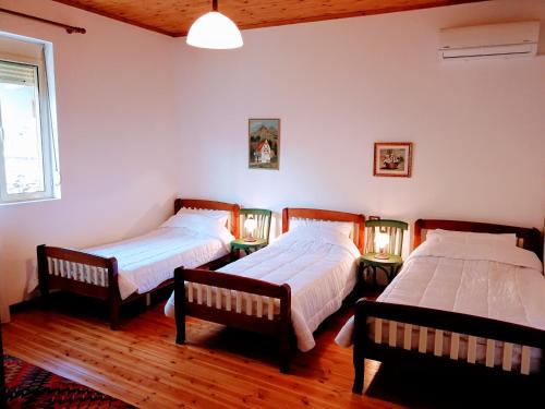 a bedroom with two beds and a window at CastleHouse in Elbasan