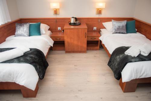 een kamer met twee bedden en twee nachtkastjes bij Geris in Częstochowa